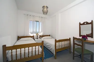 a bedroom with two beds and a mirror and a chair at 413 Casa Marsalema in Salema