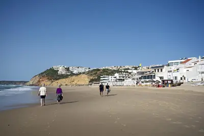 a group of people walking on the beach at 413 Casa Marsalema in Salema