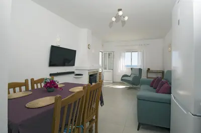 a living room with a table and a couch and a tv at 413 Casa Marsalema in Salema