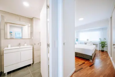 a white bedroom with a bed and a sink at Apartamento Feliz by Amazing Madeira in Funchal