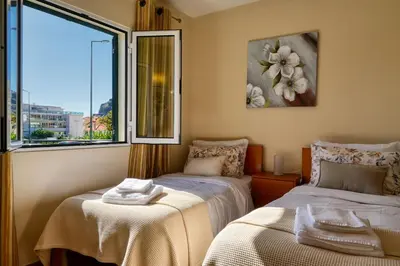 two beds in a room with a window at Largo dos Milagres, a Home in Madeira in Machico