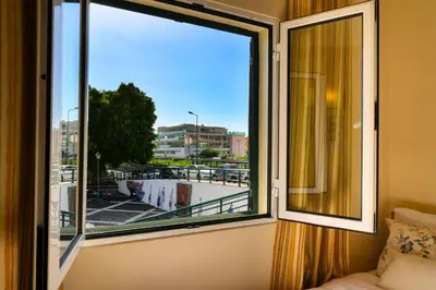a bedroom with a window with a view of a city at Largo dos Milagres, a Home in Madeira in Machico