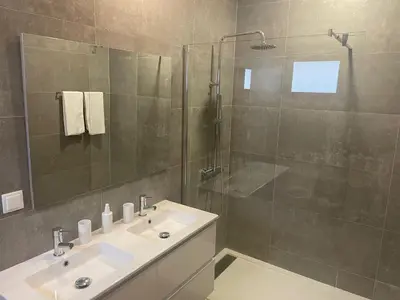 a bathroom with a sink and a glass shower at Villa Sea View in Arco da Calheta