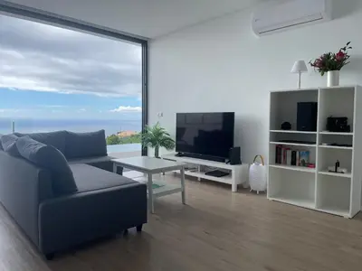 a living room with a couch and a television at Villa Sea View in Arco da Calheta