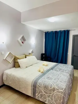 a bedroom with a large bed with blue curtains at Alojamento Central I - Funchal in Funchal