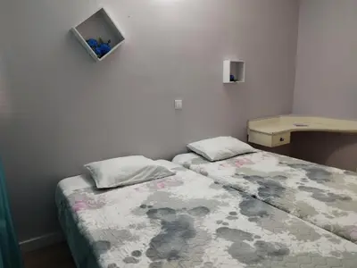 a small bedroom with two beds and a desk at Alojamento Central I - Funchal in Funchal