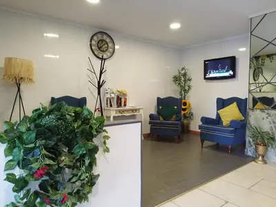 a waiting room with two chairs and a clock on the wall at Alojamento Central I - Funchal in Funchal
