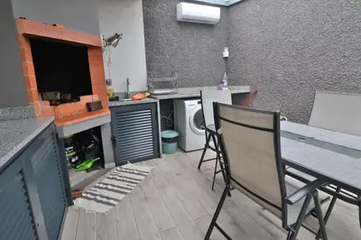 a kitchen with a table and chairs and a counter top at Vila Castro in Estreito da Calheta