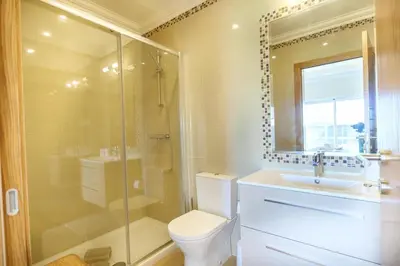 a bathroom with a toilet and a shower and a sink at Casa da Boa Vida at Boa Vista Golf Resort Bayview in Lagos