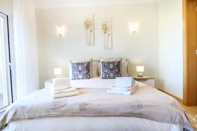 a bedroom with a large bed with towels on it at Casa da Boa Vida at Boa Vista Golf Resort Bayview in Lagos