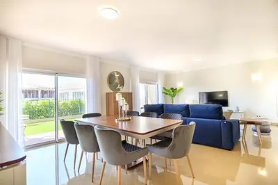a living room with a table and a blue couch at Casa da Boa Vida at Boa Vista Golf Resort Bayview in Lagos