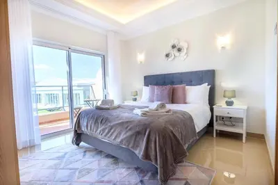 a bedroom with a large bed and a large window at Casa da Boa Vida at Boa Vista Golf Resort Bayview in Lagos