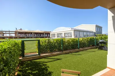 a garden with a fence and a building at Casa da Boa Vida at Boa Vista Golf Resort Bayview in Lagos
