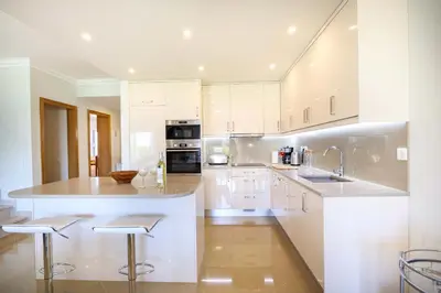 a large kitchen with white cabinets and a counter at Casa da Boa Vida at Boa Vista Golf Resort Bayview in Lagos