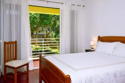 a bedroom with a bed and a large window at Lido Gardens Funchal in Funchal