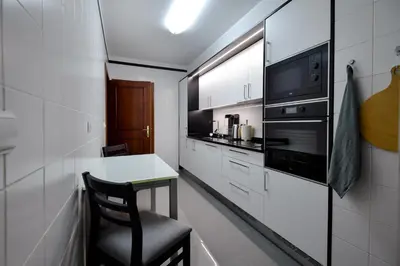 a small kitchen with a table and a chair at Lido Gardens Funchal in Funchal