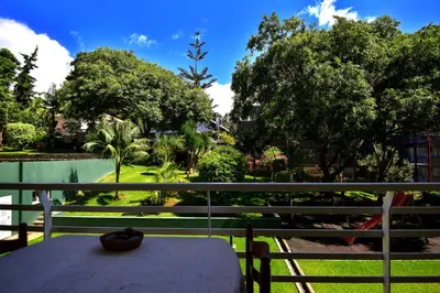a table on a balcony with a view of a park at Lido Gardens Funchal in Funchal