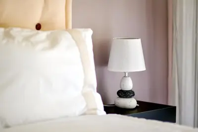 a lamp sitting on a table next to a bed at Lido Gardens Funchal in Funchal