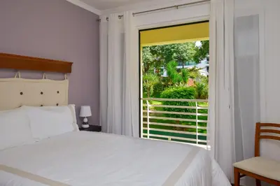 a bedroom with a bed and a large window at Lido Gardens Funchal in Funchal