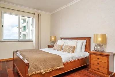a bedroom with a bed with two lamps and a window at Bellemar Apartment by Homie in Funchal