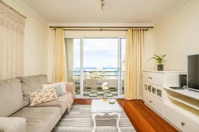 a living room with a couch and a large window at Bellemar Apartment by Homie in Funchal