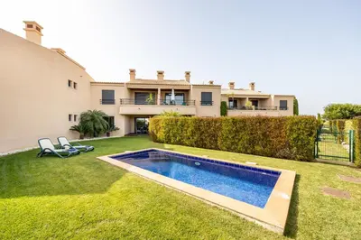 a yard with a swimming pool in front of a house at CoolHouses Algarve, Luz 2 bed elegant flat, private pool & garden, SPA facilities, Mar da Luz 19 in Luz