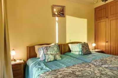 a bedroom with a bed and a lamp on a night stand at Palheiro Residence Familiar 2 in Funchal