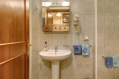 a bathroom with a sink and a mirror at Palheiro Residence Familiar 2 in Funchal