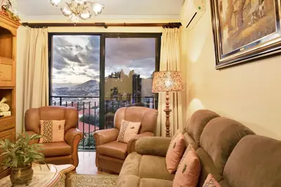 a living room with a couch and two chairs and a window at Palheiro Residence Familiar 2 in Funchal