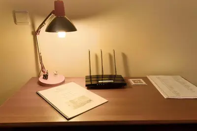 a desk with a lamp and papers on it at Palheiro Residence Familiar 1 in Funchal