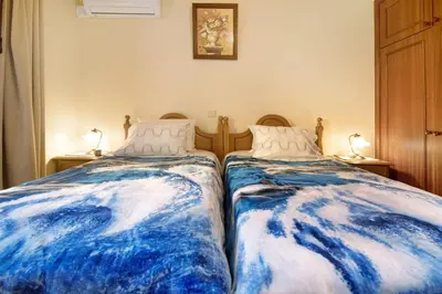 two beds sitting next to each other in a bedroom at Palheiro Residence Familiar 1 in Funchal