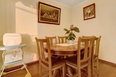 a dining room with a table and chairs with a potted plant at Palheiro Residence Familiar 1 in Funchal