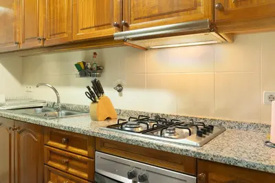 a kitchen with a stove and a sink at Palheiro Residence Vista Mar in Funchal