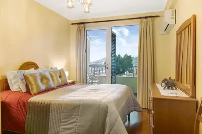 a bedroom with a bed with a cat sitting on a table at Palheiro Residence Vista Mar in Funchal