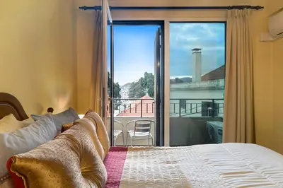 a bedroom with a large wooden bed with pillows at Palheiro Residence Vista Mar in Funchal