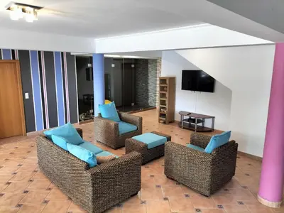 a living room with wicker chairs and a tv at Villa Fanny in Ribeira Brava