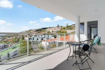 a balcony with a table and chairs and a view at Apartment Nata by Holiday Rental Madeira in Caniço