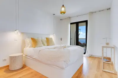 a white bedroom with a large white bed with yellow pillows at Apartment Nata by Holiday Rental Madeira in Caniço
