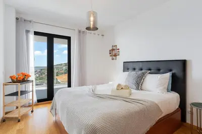 a bedroom with a large bed with a large window at Apartment Nata by Holiday Rental Madeira in Caniço