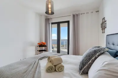 a bedroom with a bed with a view of the ocean at Apartment Nata by Holiday Rental Madeira in Caniço