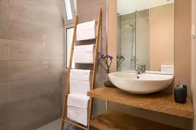 a bathroom with a white sink and a mirror at Villa da Silva (Heated Pool and Private Parking) in Arco da Calheta