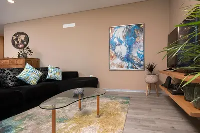 a living room with a black couch and a glass table at Villa da Silva (Heated Pool and Private Parking) in Arco da Calheta
