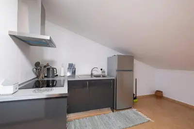 a kitchen with a stainless steel refrigerator and a sink at Sara House in Ponta do Sol