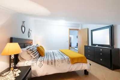 a bedroom with a bed and a dresser and a television at Sara House in Ponta do Sol