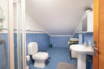 a blue bathroom with a toilet and a sink at Sara House in Ponta do Sol
