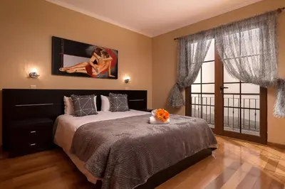 a bedroom with a bed and a large window at KING´S HOUSE (Sea View and Indoor BBQ) in Estreito da Calheta