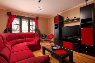 a living room with a red couch and a tv at KING´S HOUSE (Sea View and Indoor BBQ) in Estreito da Calheta
