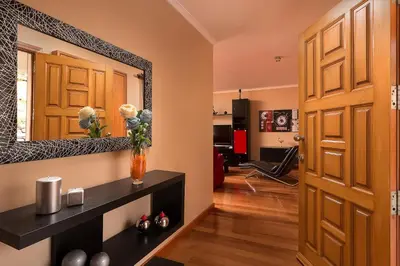 a room with a door and a vase with flowers on a shelf at KING´S HOUSE (Sea View and Indoor BBQ) in Estreito da Calheta
