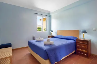 a bedroom with a blue bed and a window at Casa de férias a 75 metros da praia in Campo de Baixo