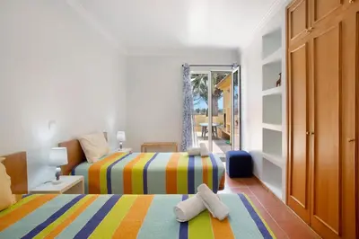 a bedroom with two beds with towels on them at Casa de férias a 75 metros da praia in Campo de Baixo